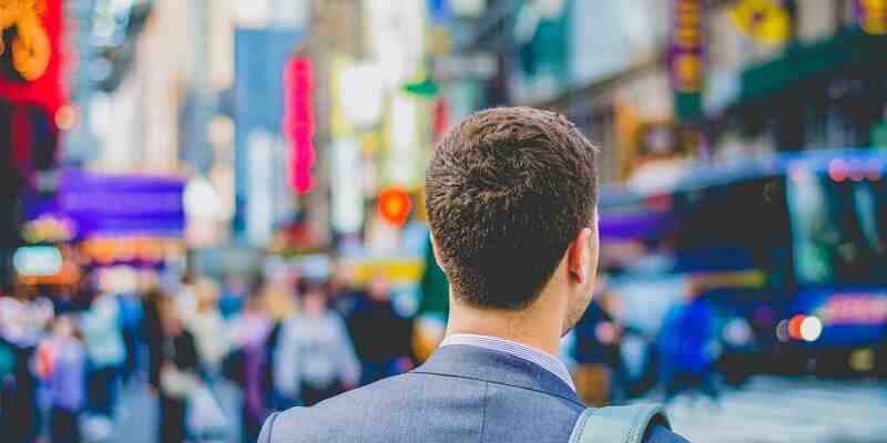 A man in a suit in a busy city