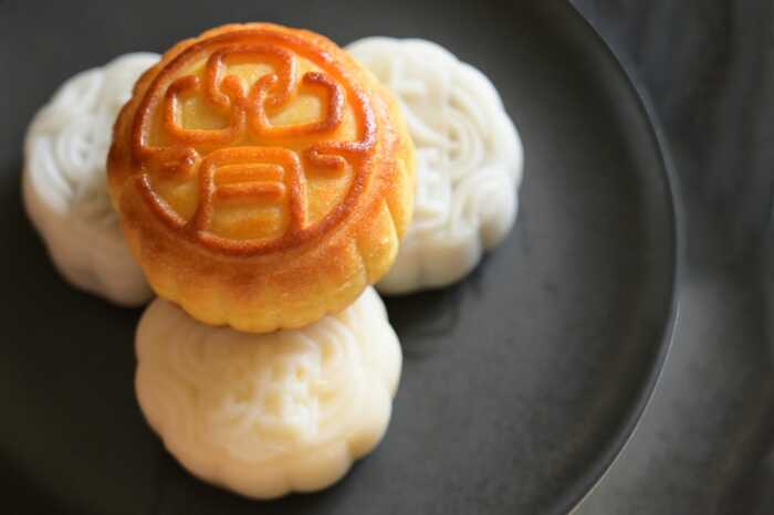 Stacked moon cakes on a black plate