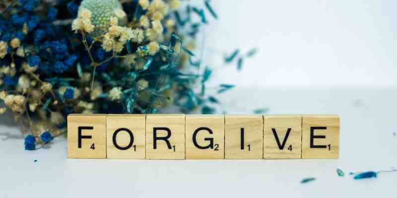 Forgive, written in children's blocks with flowers behind it'