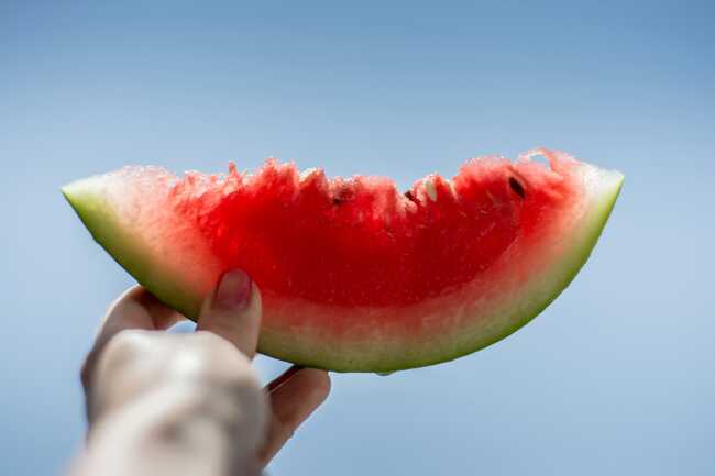 Someone holding a piece of watermelon