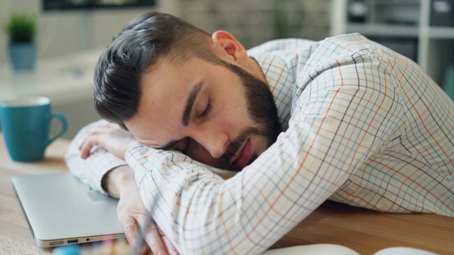 A person taking a nap on his work table