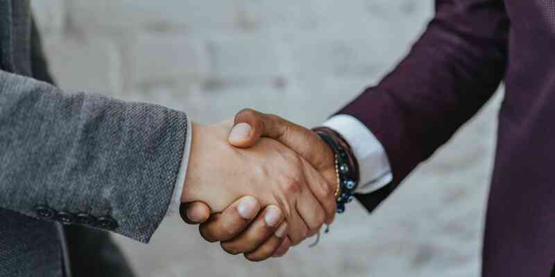 Two men in suits shaking hands