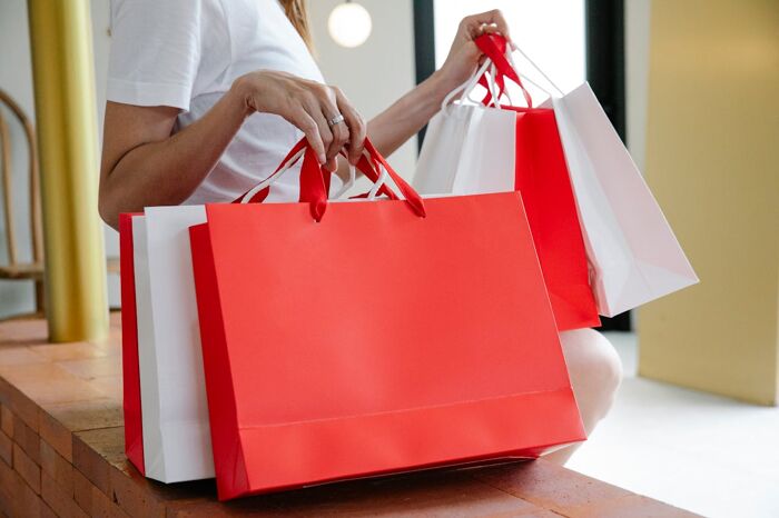 A woman holding red and white shopping bags