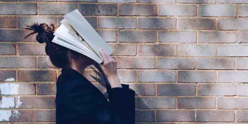 Woman with books on her face