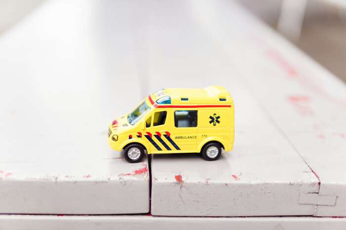 A yellow toy ambulance on a white table